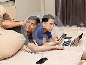 Happy middle aged asian gay couple using holiday together at home