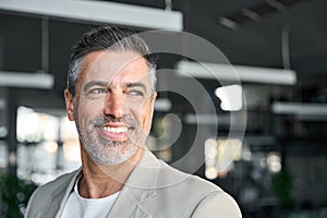 Happy middle aged business man in office looking away. Headshot portrait