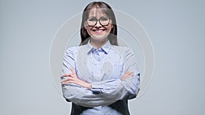 Happy middle aged businesswoman with arms crossed over gray background