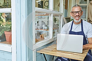 Happy middle aged caucasian man working on computer