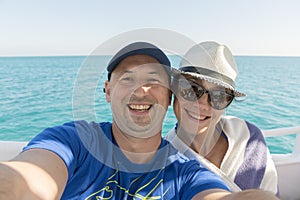 Happy middle aged couple taking selfie on yacht. Beautiful happy couple taking selfie on yacht deck floating in sea. Sailing,