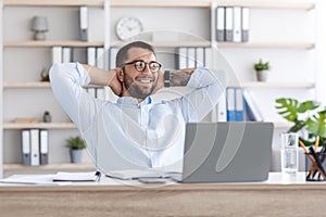 Happy middle aged european businessman in glasses have break from work behind laptop in living room