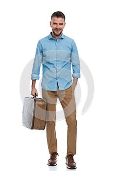 Happy middle aged guy with luggage going to vacation and enjoying his holiday