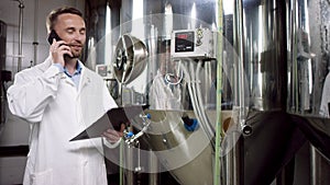 A happy middle-aged labouring man is reporting on the condition of a laboratory equipment. A side view slow motion close