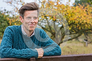 Happy Middle Aged Man Outside Leaning on a Fence