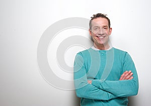 Happy middle aged man smiling with arms crossed