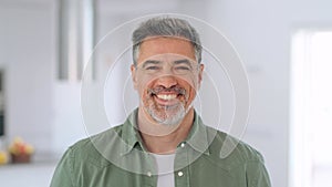 Happy middle aged man standing looking at camera at home. Portrait.