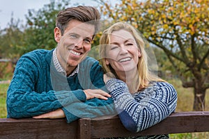 Happy Middle Aged Man Woman Couple Leaning on Fence in The Countryside