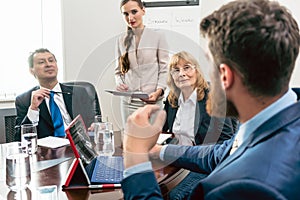 Happy middle-aged managers listening to their younger colleague