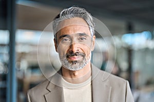 Happy middle aged mature business man looking at camera in office, headshot.