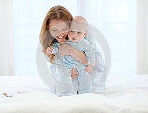 Happy middle aged mother with her child in a bed