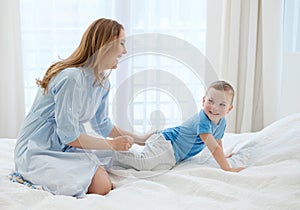 Happy middle aged mother with her child in a bed