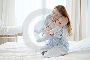 Happy middle aged mother with her child in a bed