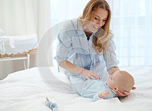 Happy middle aged mother with her child in a bed