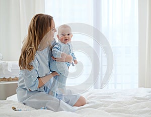 Happy middle aged mother with her child in a bed