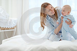 Happy middle aged mother with her child in a bed