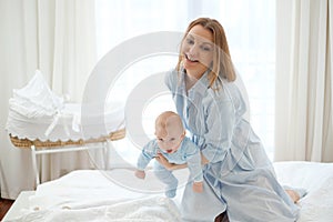 Happy middle aged mother with her child in a bed