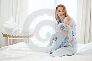 Happy middle aged mother with her child in a bed