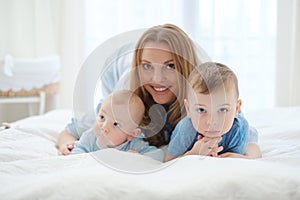 Happy middle aged mother with her children in a bed