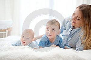 Happy middle aged mother with her children in a bed