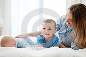 Happy middle aged mother with her children in a bed