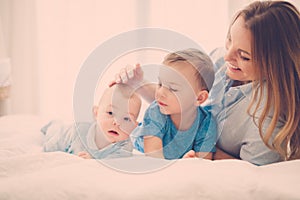 Happy middle aged mother with her children in a bed