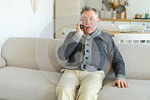 Happy middle aged senior man talking on smartphone with family friends. Older mature grandfather with cell phone talking