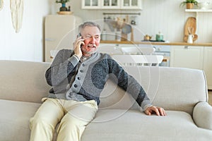 Happy middle aged senior man talking on smartphone with family friends. Older mature grandfather with cell phone talking