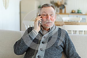 Happy middle aged senior man talking on smartphone with family friends. Older mature grandfather with cell phone talking