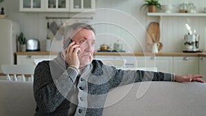 Happy middle aged senior man talking on smartphone with family friends. Older mature grandfather with cell phone talking