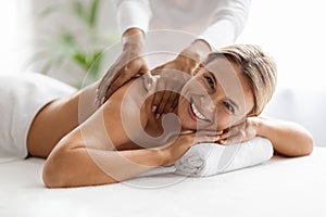 Happy Middle Aged Woman Enjoying Body Massage Session In Luxury Spa Salon