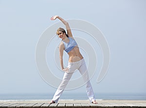 Happy middle aged woman exercising at beach