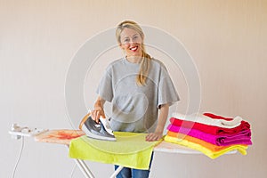 Happy middle aged woman ironing clothes