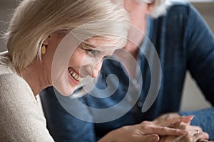Happy middle-aged woman laughing flirting with beloved older man