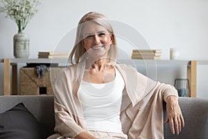 Happy middle aged woman looking at camera at home