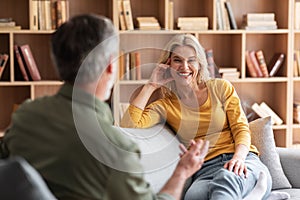 Happy Middle Aged Woman And Man Chatting While Relaxing Together On Couch