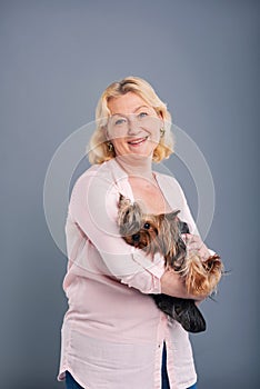 Happy middle-aged woman posing with her dog