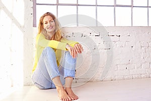 Happy middle aged woman relaxing on the floor