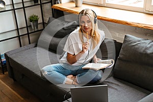 Happy middle-aged woman using laptop while studying at home