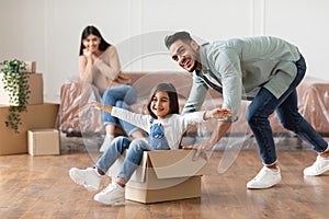 Happy middle eastern family celebrating moving day in new apartment