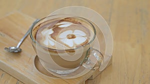 Happy with milk coffee. hot ceramic white coffee cup with smoke on saucer over wooden table. A mug of fragrant coffee invigorates