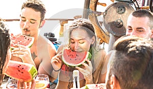 Happy millenial friends having fun at sail boat party with watermelon sangria and champagne - Cool friendship concept photo