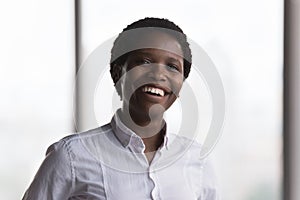 Happy millennial African businesswoman in formal shirt head shot portrait