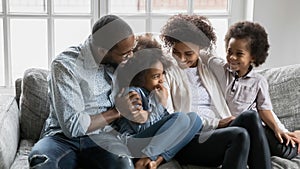 Happy millennial black married couple and two kids enjoying leisure