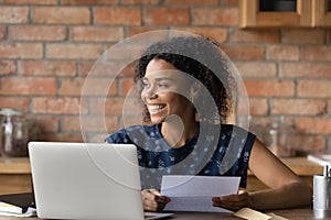 Happy millennial Black student girl receiving paper letter, invitation