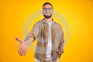 Happy millennial caucasian man with beard in casual and glasses give hand for handshake