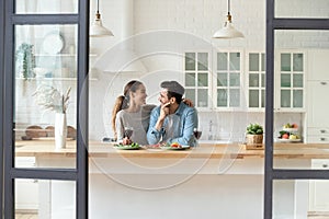 Happy millennial couple enjoy weekend in modern kitchen