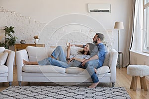 Happy millennial couple of homeowners enjoying cool conditioned air