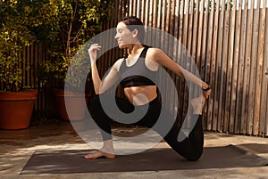 Happy millennial european woman athlete in sportswear practicing yoga in city, enjoy breath exercises