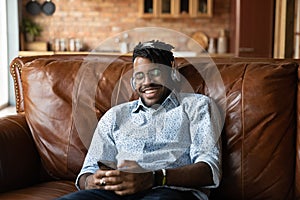 Happy millennial hipster Black guy wearing headphones